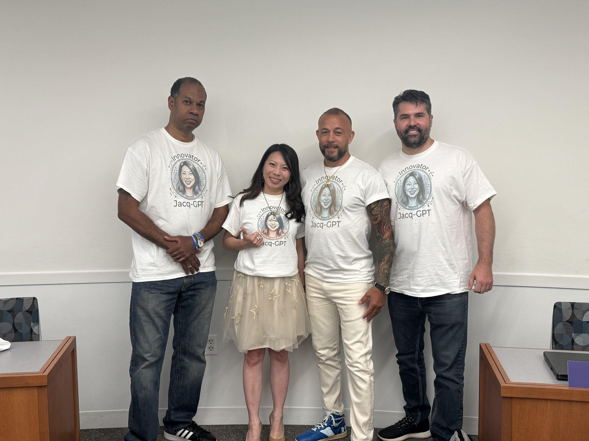 Alvin Jones, Jacqueline Liu, Stephen Bernous and James Haselton, all wearing white “Innovator Jacq-GPT” T-shirts printed with her illustrated portrait